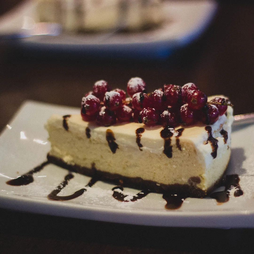 Berry-topped cheesecake with chocolate sauce