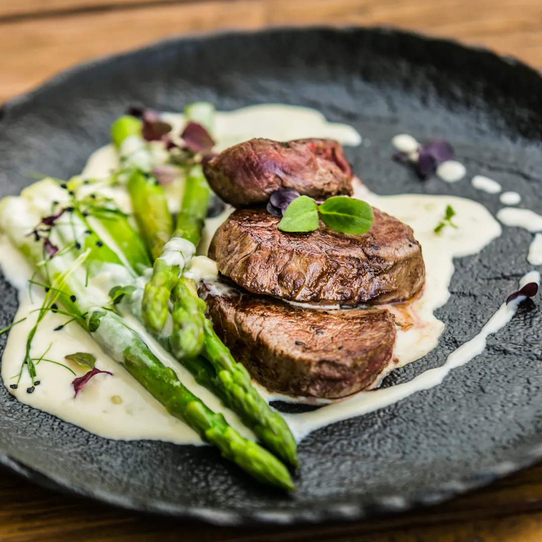 Sliced steak with asparagus and cream sauce