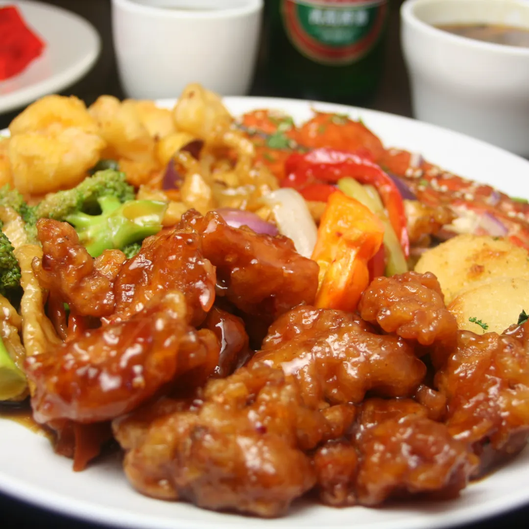 Glazed chicken with vegetables and fried sides